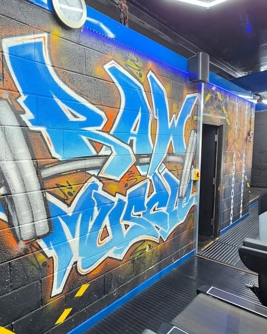 The old wall with the RAW MUSCLE graffiti mural